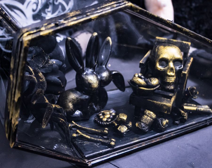 Glasvitrine mit Hasenfiguren, Totenkopf auf einem Thron und kleinen Kuriositäten
